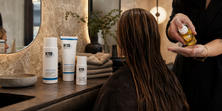 Escena editorial de reparación molecular del cabello con K18 y brillo natural